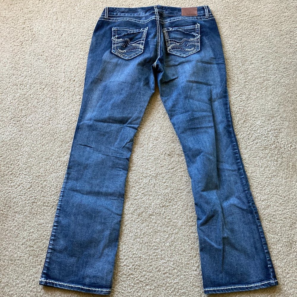 USED MAURICE DARK DENIM JEANS EMBRODIERED STITCH ON BACK POCKET IN WAVE DESIGN.